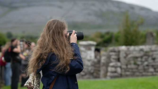 colored photograph of vivian taking pictures with a Nikon camera in ireland landscape
