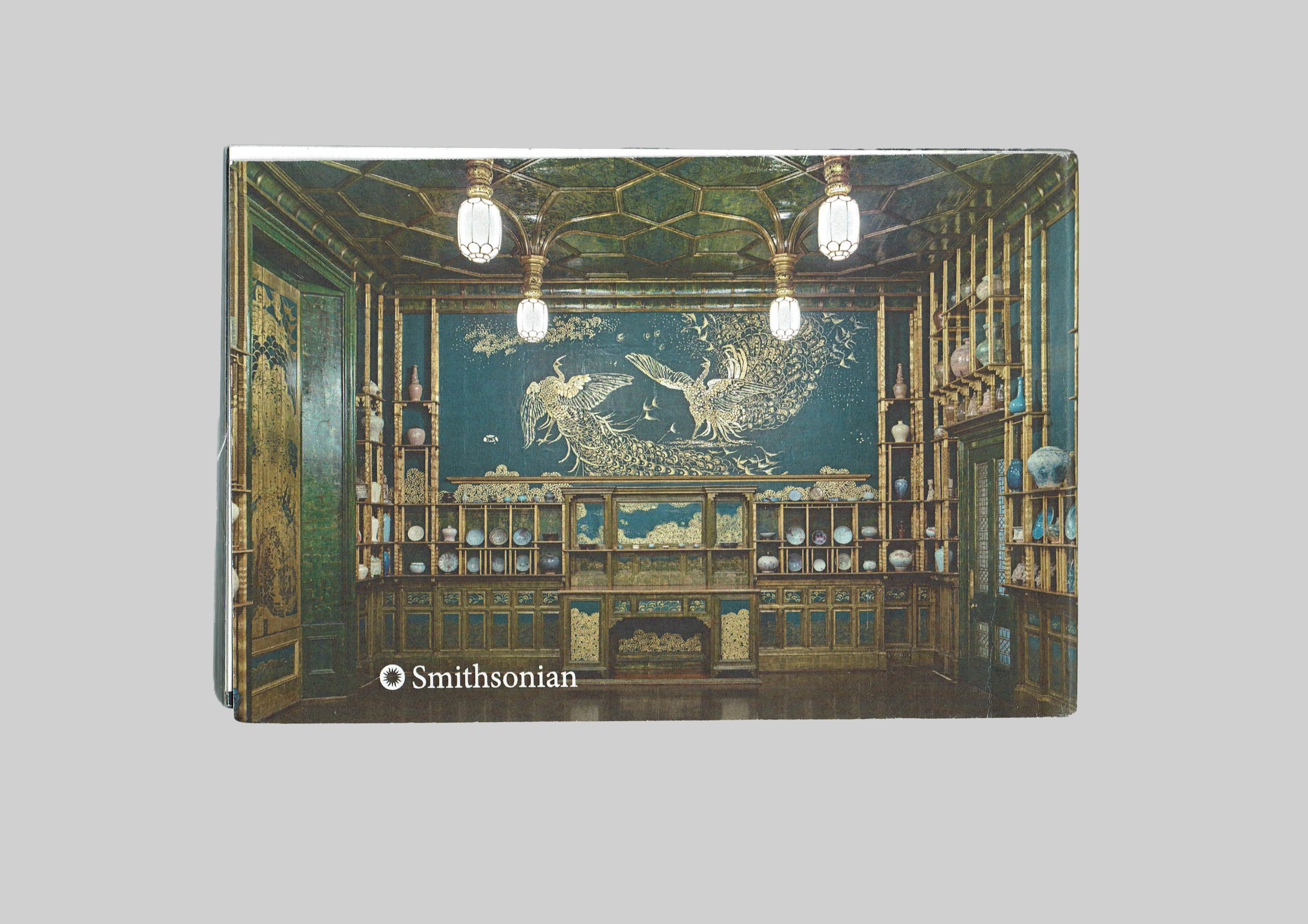 back cover of the museum catalog which is an image of the northern wall of the peacock rom overlaid with white text