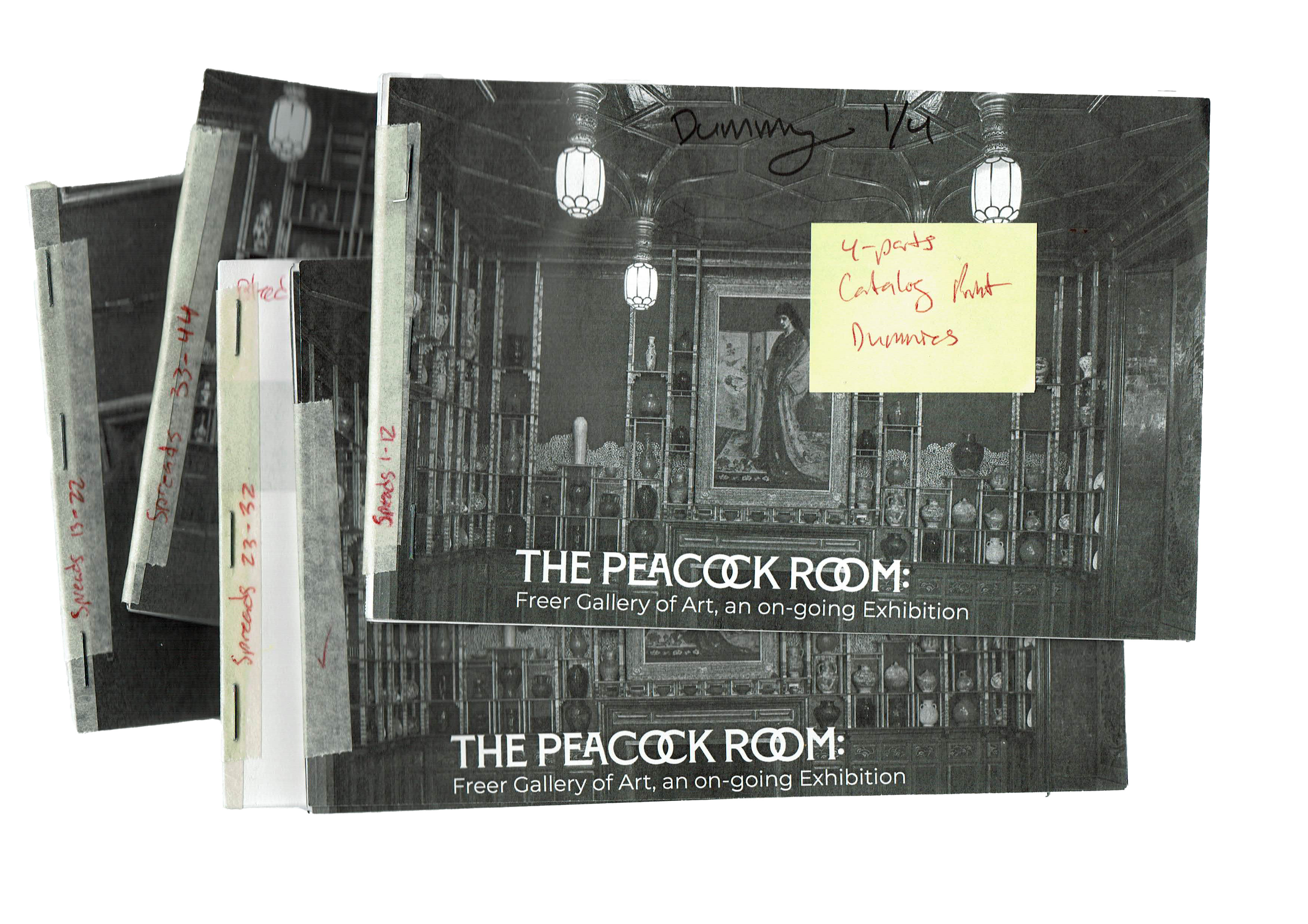 scanned image of taped and stapled dummy prints or demo prints of four black and white trial booklets of the catalog within this scan includes a yellow sticky note identifying what these demo books are for